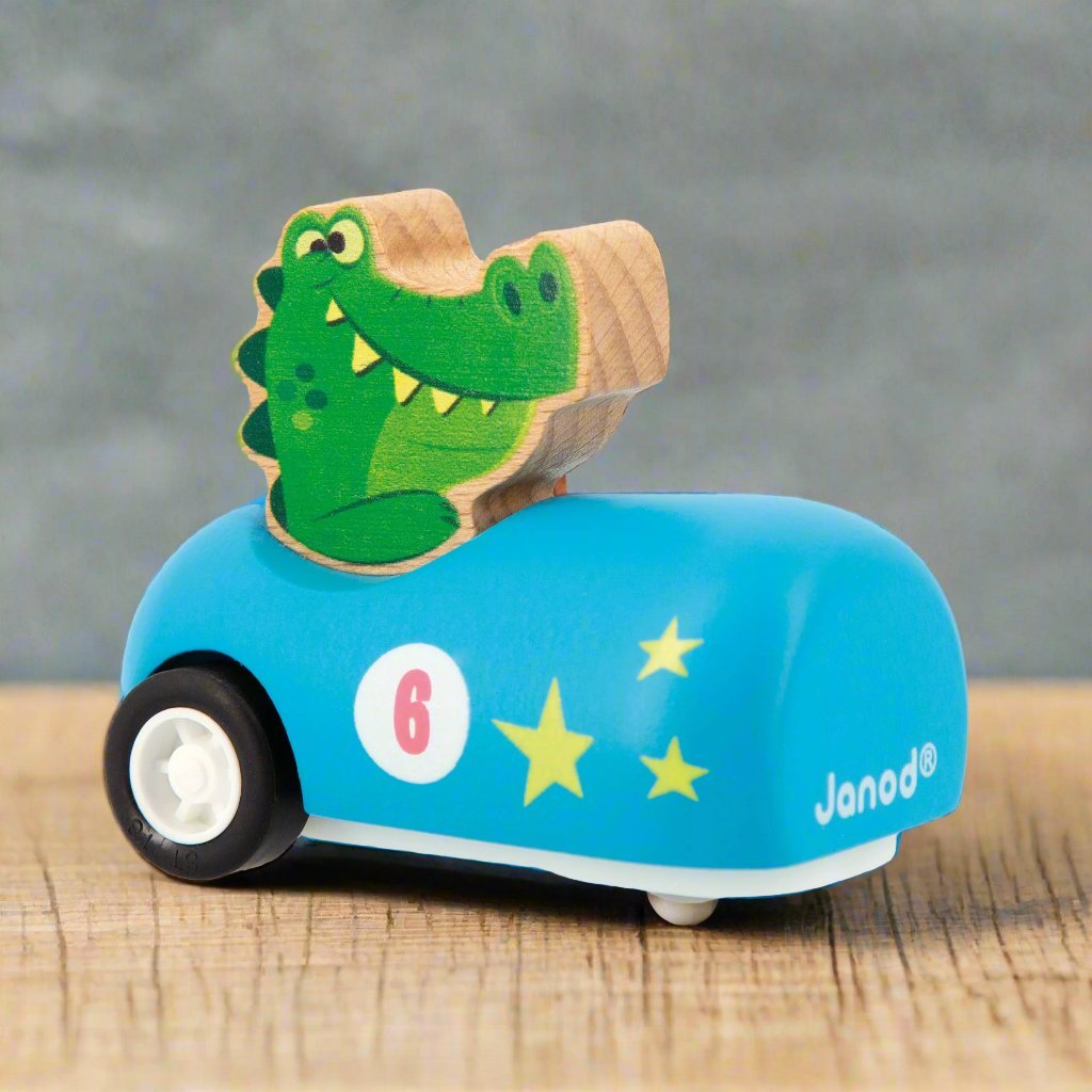 Alligator sitting in a light blue Wooden Pull-Back Car by Janod