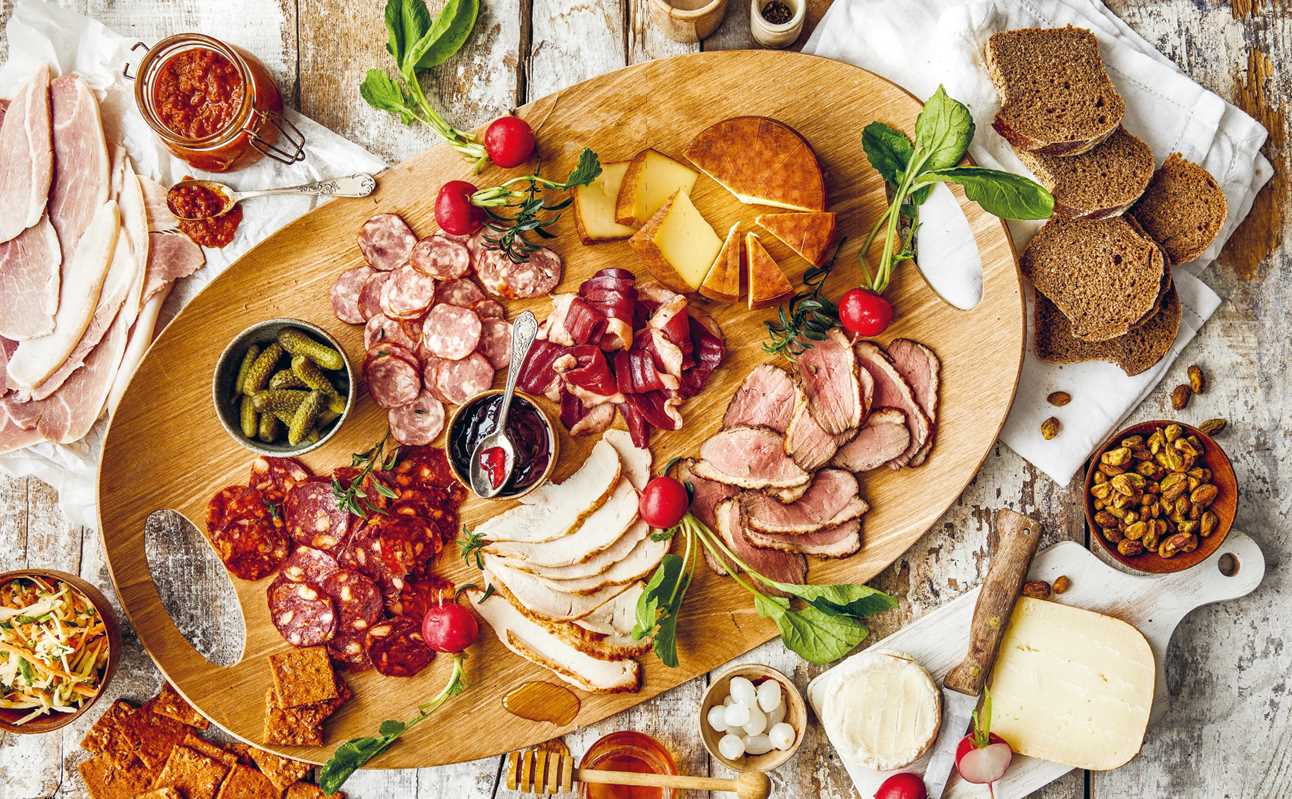 Charcuterie board layout with salami and fruit using ideas from Charcuterie Boards by Miranda Ballard – Entertaining Made Easy.