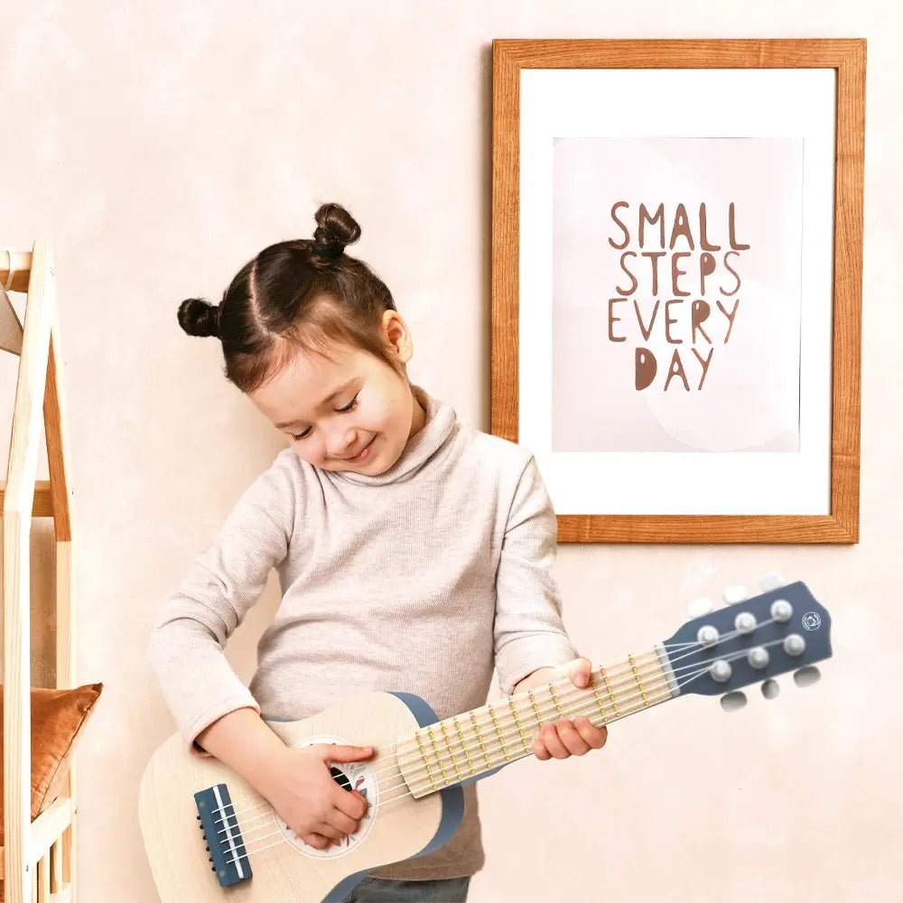 Child playing with the Children's Guitar by Speedy Monkey – a wooden toy guitar for kids.
