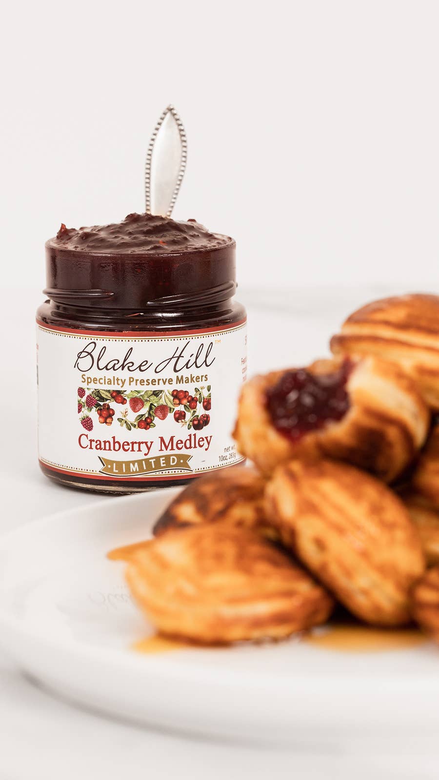 Jar of Cranberry Medley Jam from Blake Hill Preserves spread on a plate with pastries