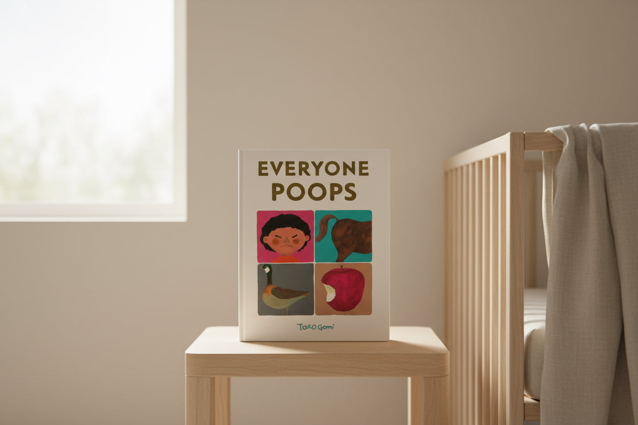 “Everyone Poops” children’s book displayed on wooden table in neutral nursery setting