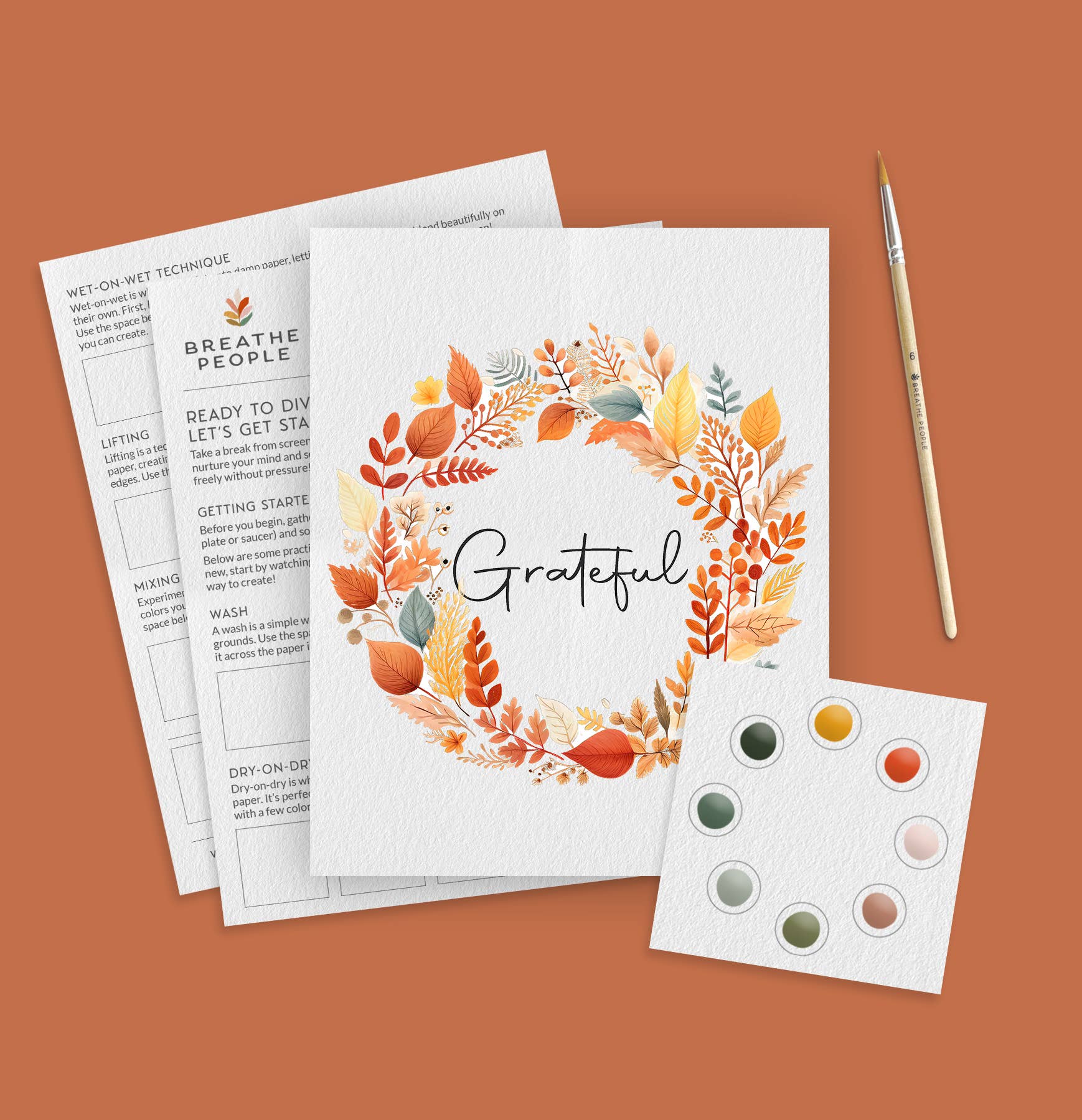 Fall Wreath Watercolor Kit, featuring an artistic print with 'Grateful' text and autumn leaves, accompanied by a paintbrush and color swatch on a brown background