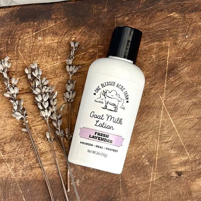 2oz Fresh Lavender Goat Milk Lotion with Lavender flowerts on a Wooden Surface