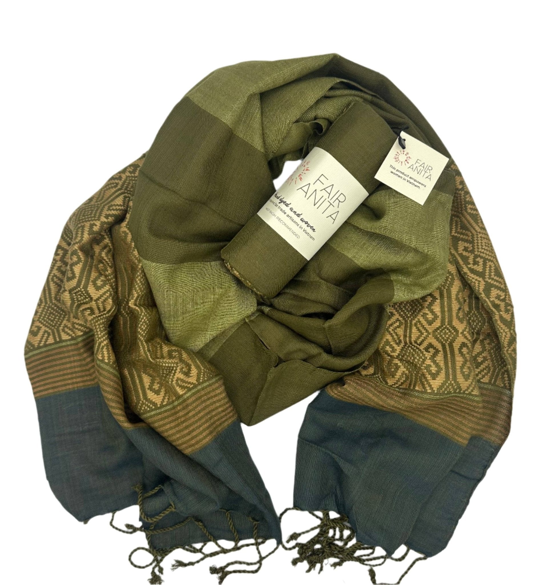 The Mossy Hillside Woven Scarf by Fair Anita features a green and brown pattern inspired by nature’s earthy tones.
