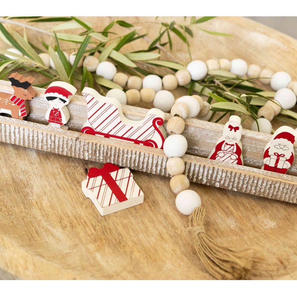 Santa Wood Shapes Letterboard on a wooden surface with beads and greenery.