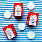 Up-close version of Seaberry shower steamers by Old Whaling Co laid out on a blue white stripe towel