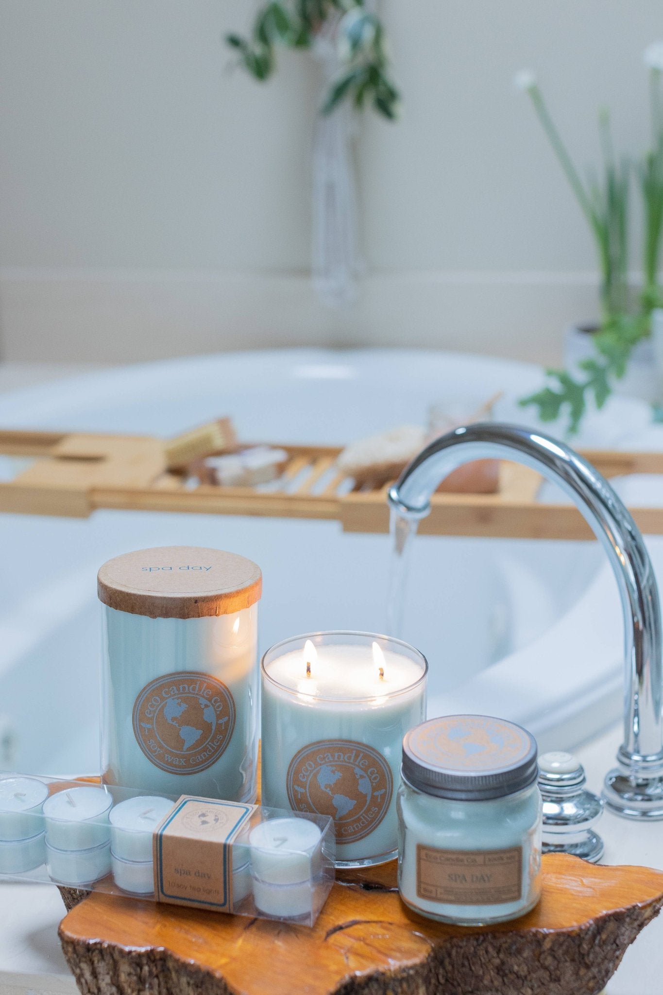 Spa Day Soy Candles and bath products by Eco Candle Company on a wooden tray by a bathtub.
