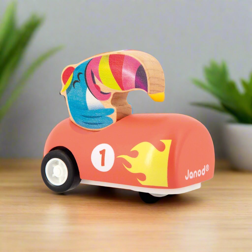 Tucan sitting in a orange Wooden Pull-Back Car by Janod