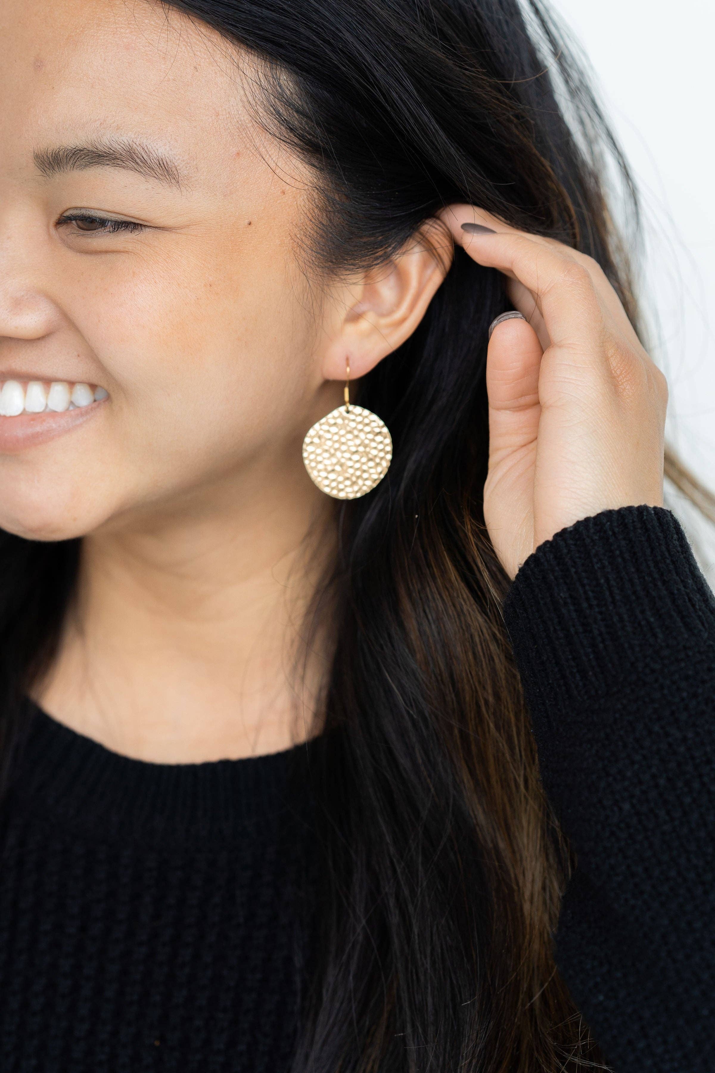 A person wearing Gold Lucia Earrings by Spiffy and Splendid.