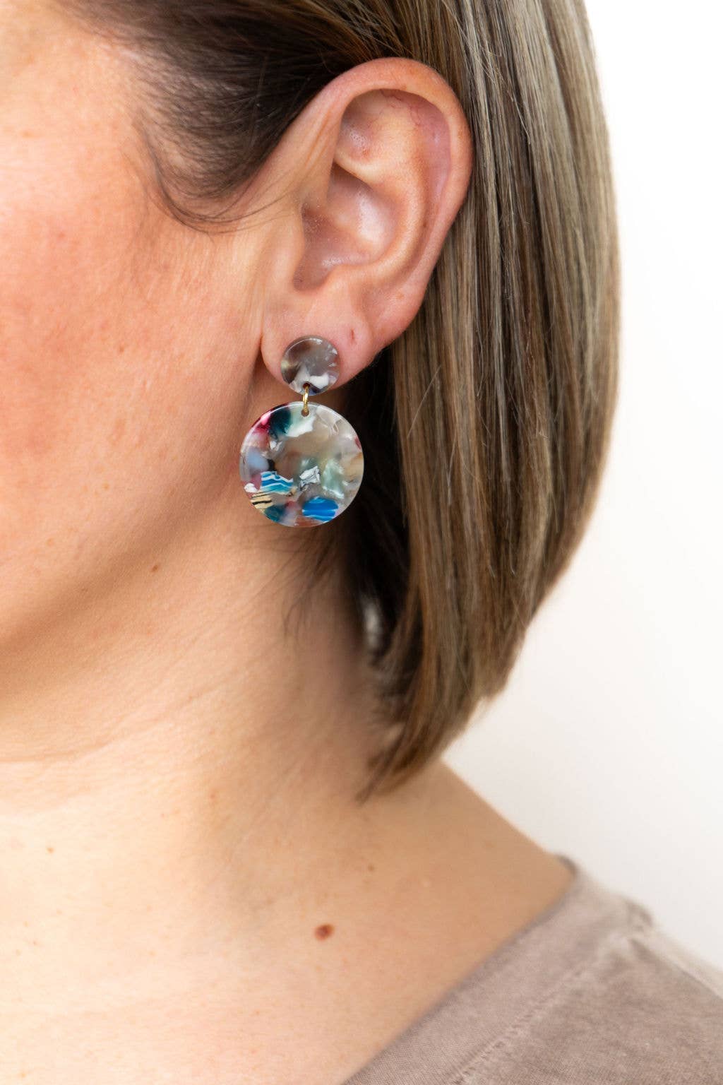 A person wearing multicolor Addy Earrings by Spiffy and Splendid.