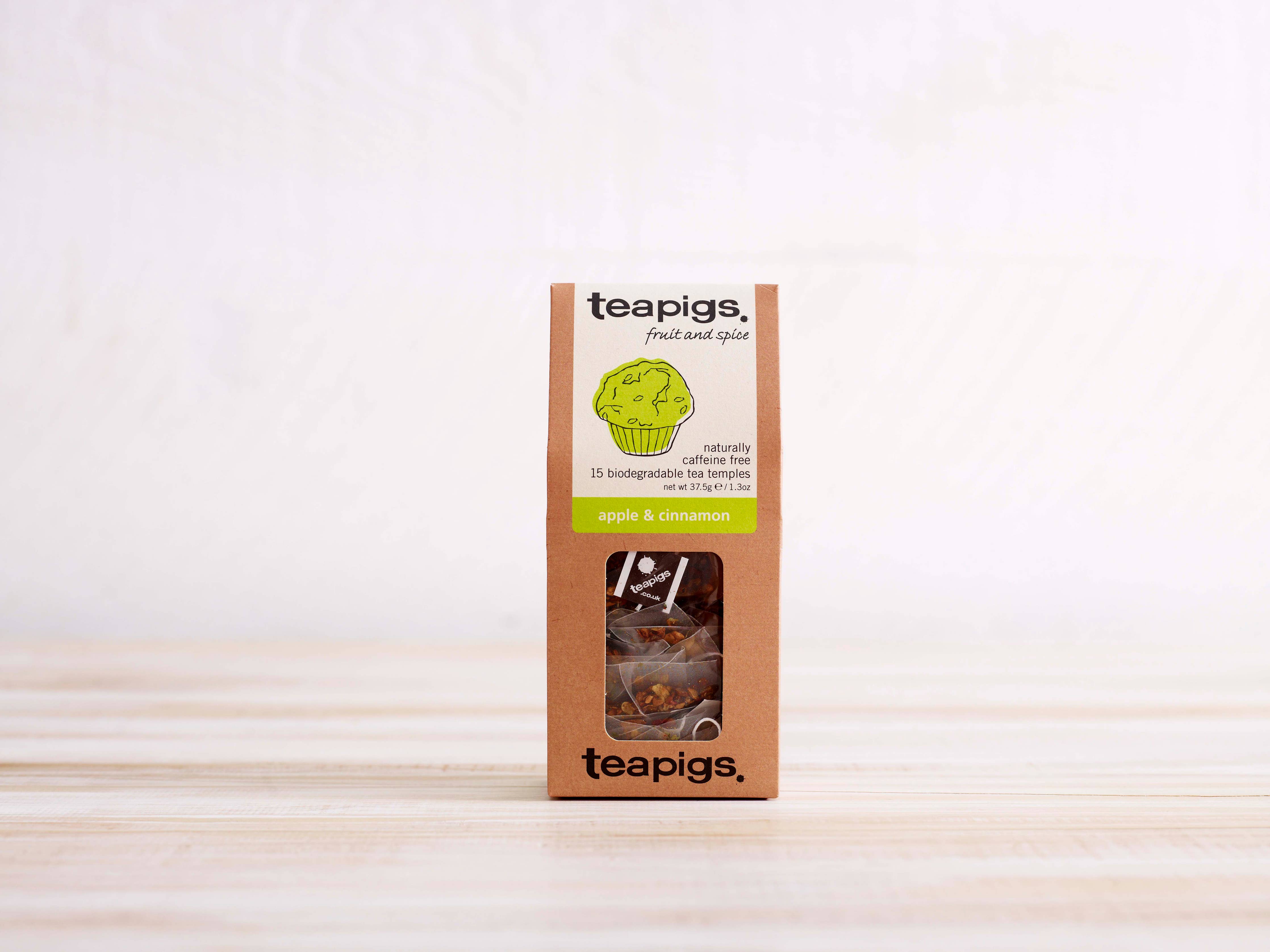 Teapigs Apple and Cinnamon Tea packaging on a wooden surface with a white background