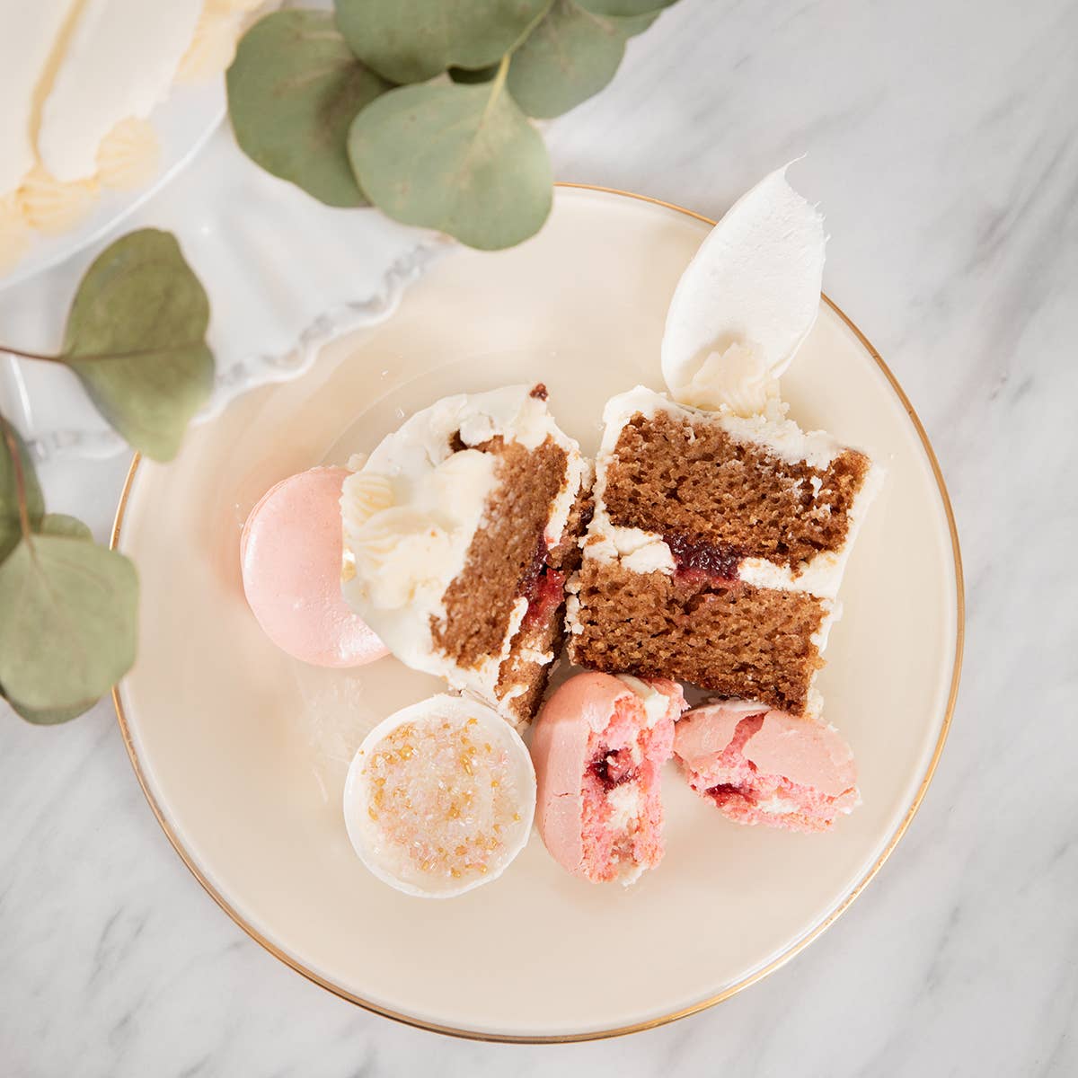 Sliced cake made with Cranberry Medley Jam from Blake Hill Preserves on a plate with decorative elements on a marble surface