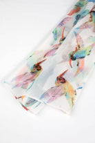 Close-up of a delicate chiffon scarf featuring a floral and hummingbird design by Ten Thousand Villages.