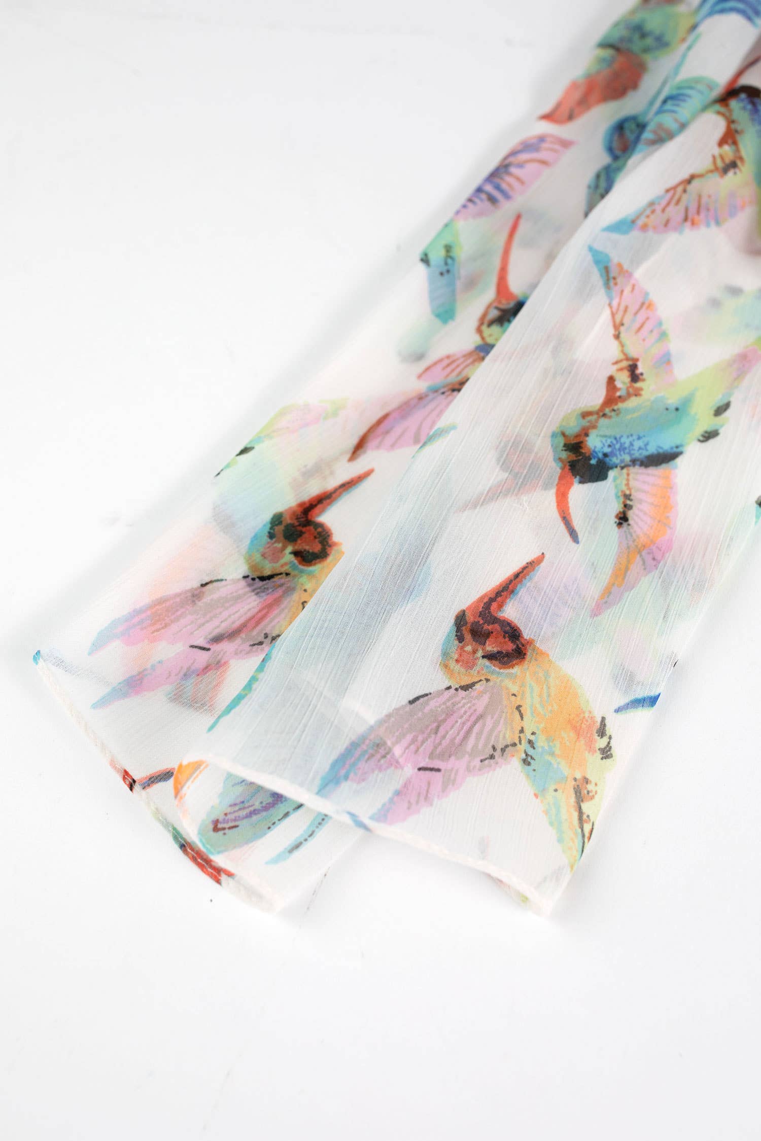 Close-up of a delicate chiffon scarf featuring a floral and hummingbird design by Ten Thousand Villages.