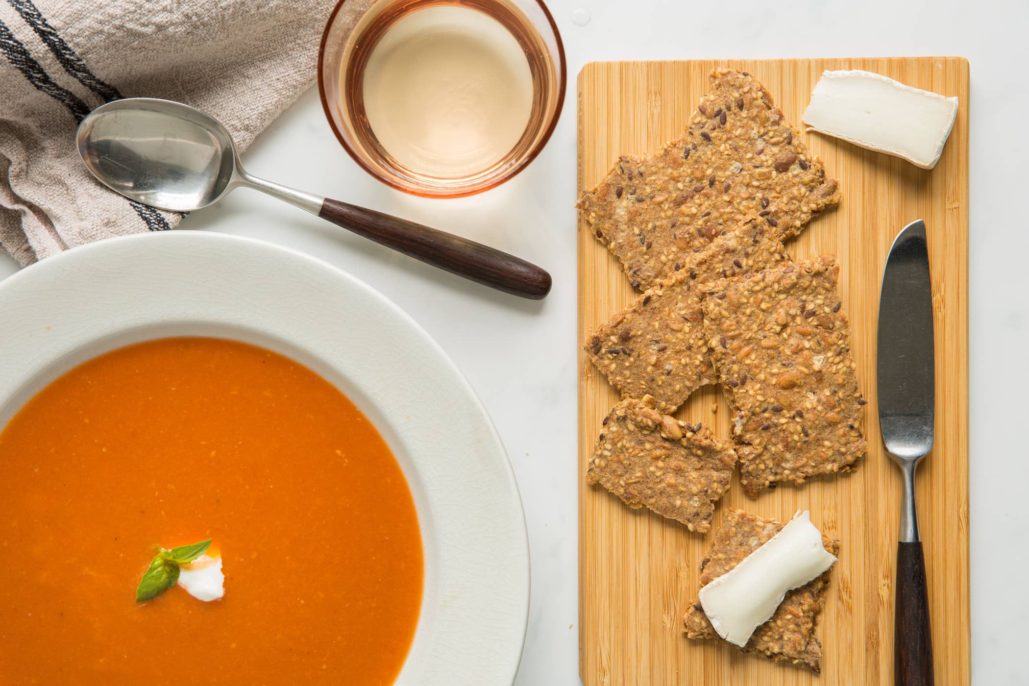 Tomato soup with crackers and cheese on a wooden board
