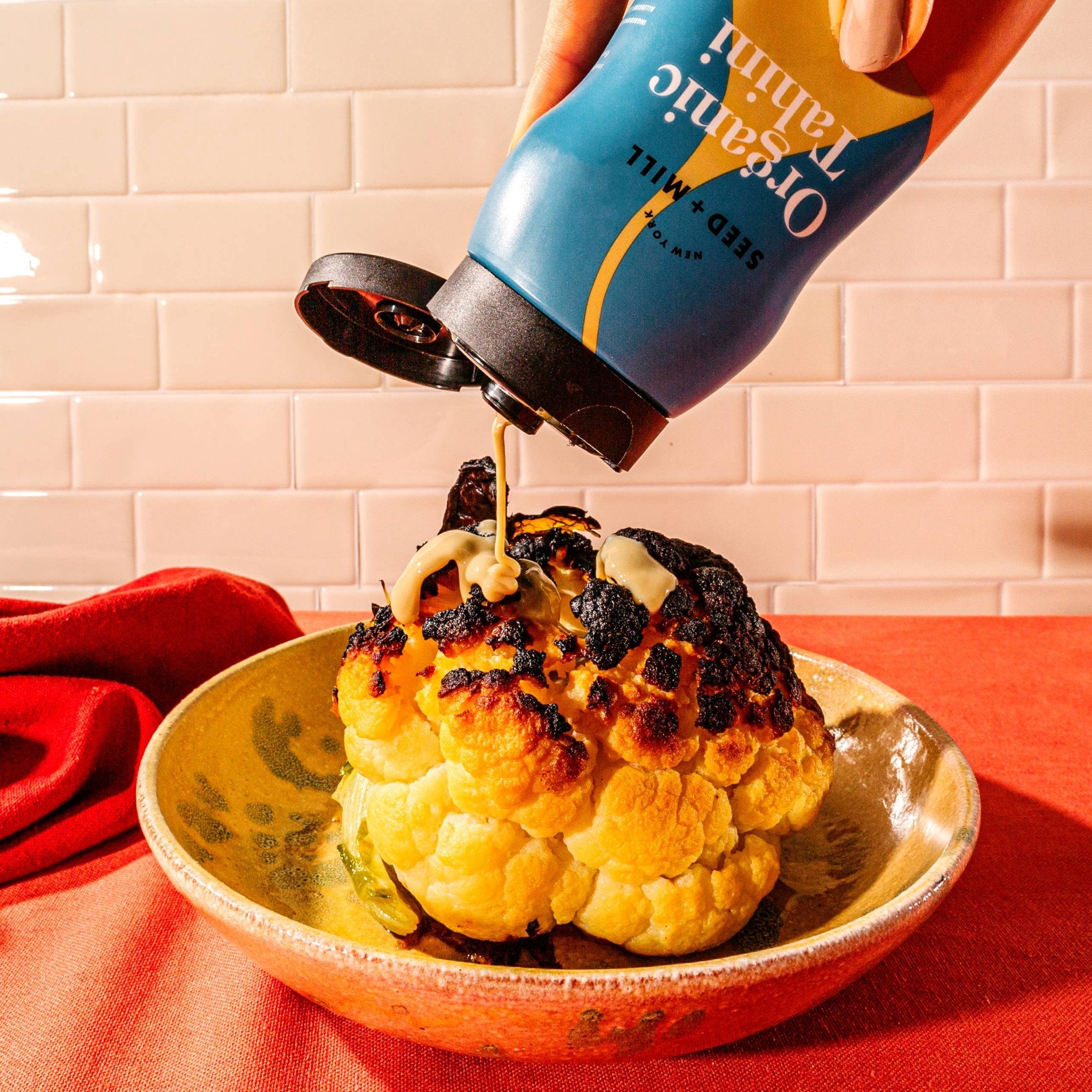 Roasted cauliflower drizzled with Organic Tahini Squeeze Bottle by Seed + Mill – vegan, gluten-free