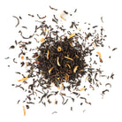 Sweet Cream Early Grey tea leaves from Apolis Tea with orange pieces on a white background