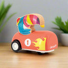 Tucan sitting in a orange Wooden Pull-Back Car