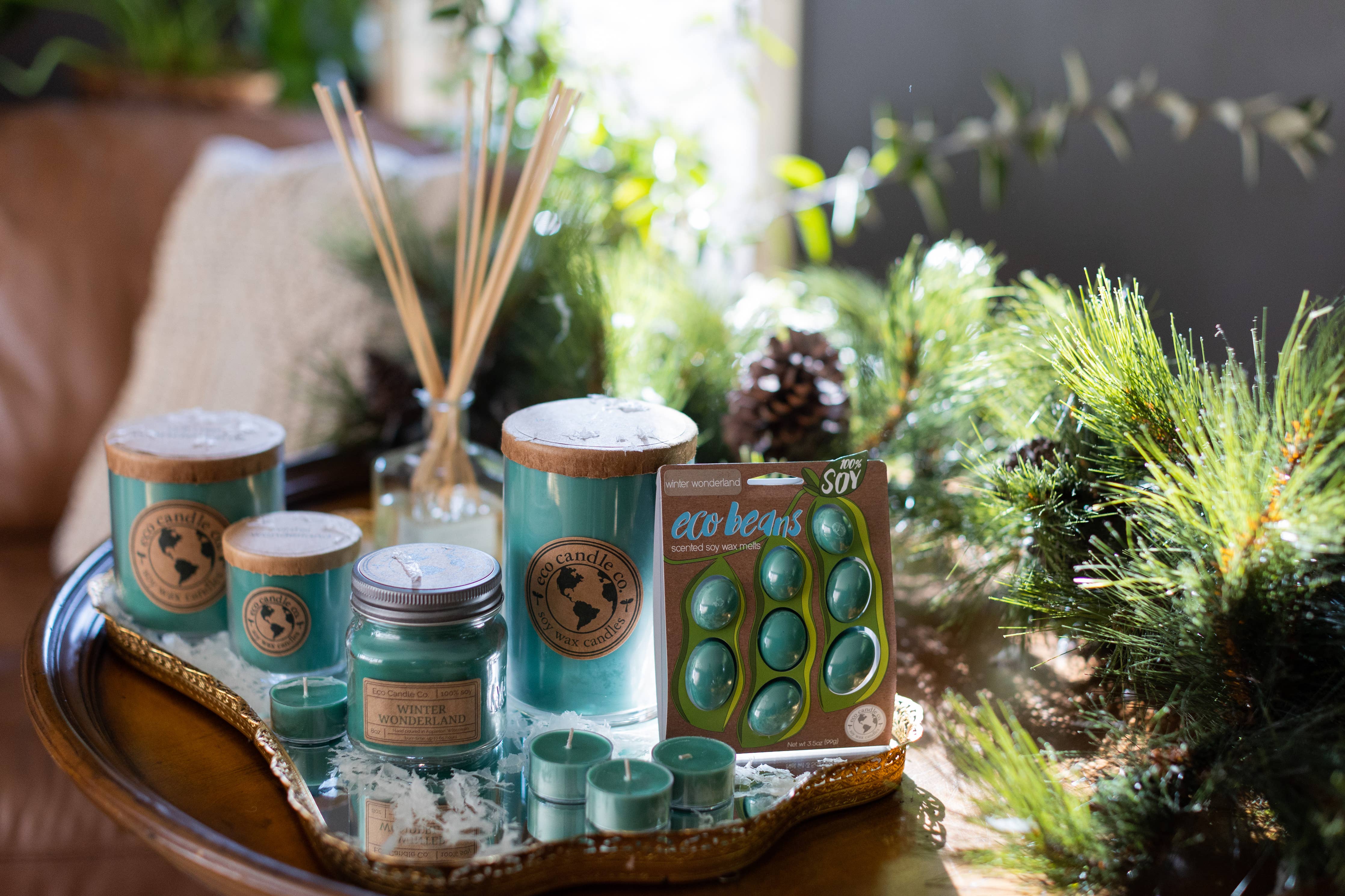 Collection of Winter Wonderland Soy Candles and diffusers by Eco Candle Co. on a decorative tray with plants in the background