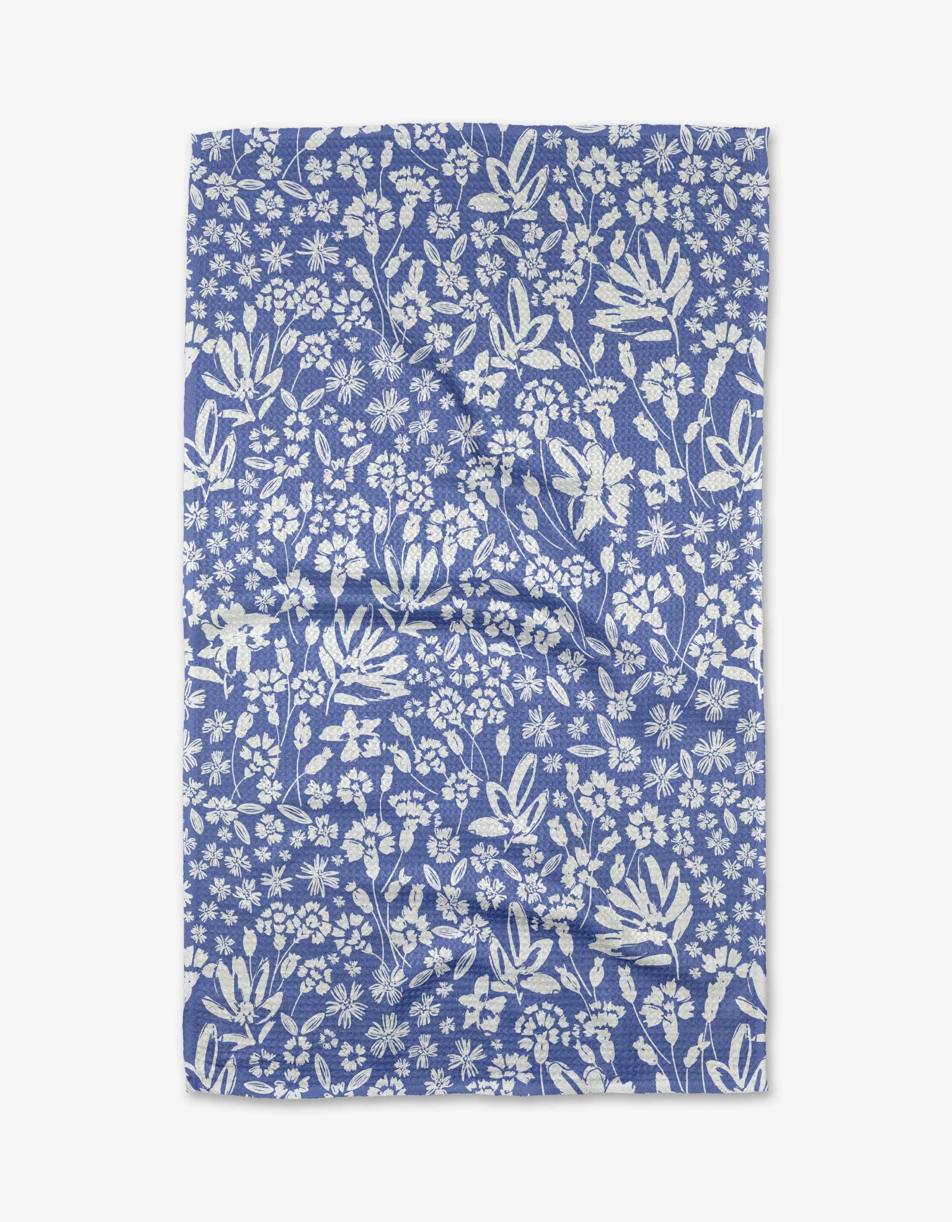 Bloom Me Over Floral Tea Towel by Geometry. Tea Towel has a white floral print on a blie background.