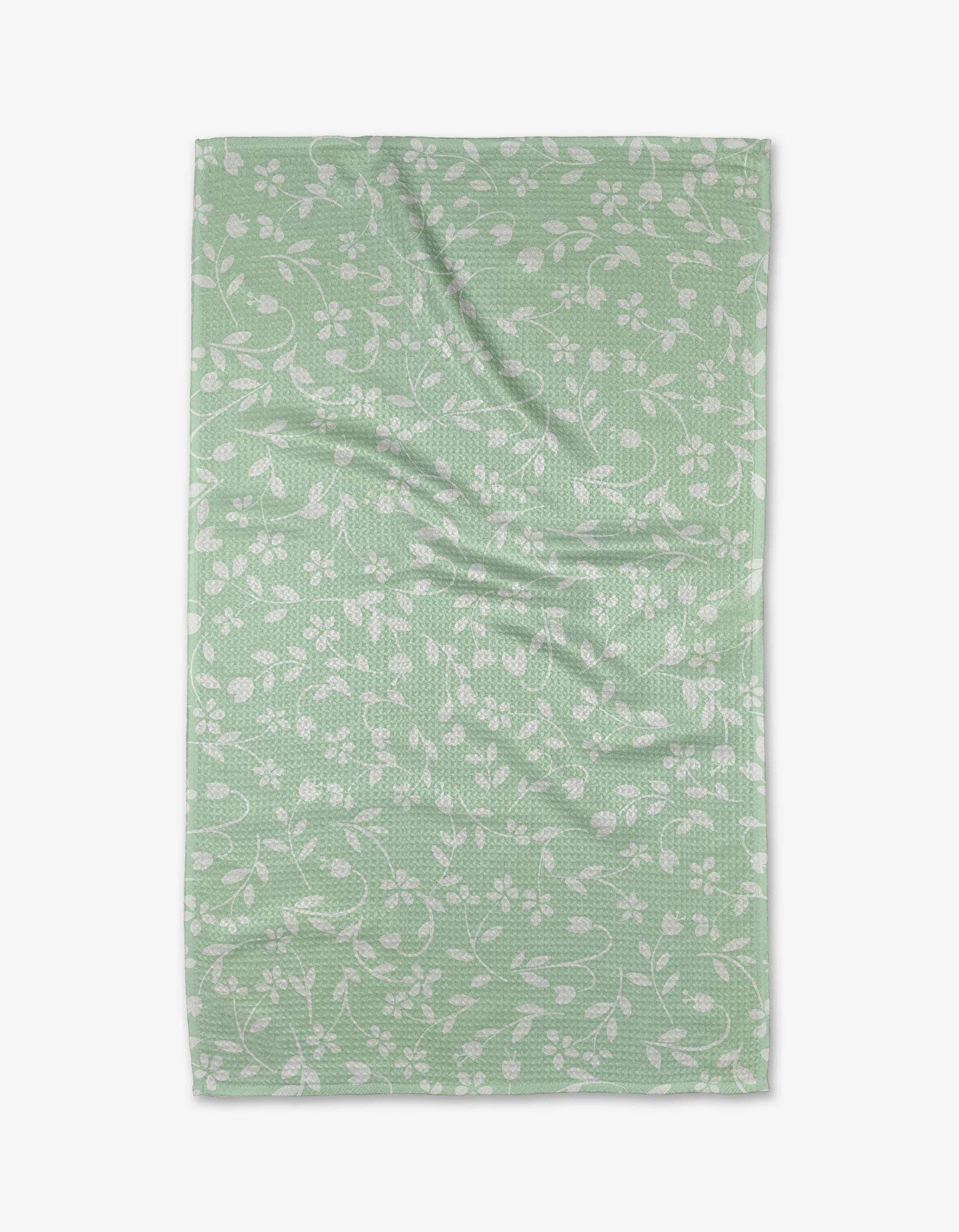 Dandy Tea Towel by Geometry. Tea Towel has a white florals on a light green background.
